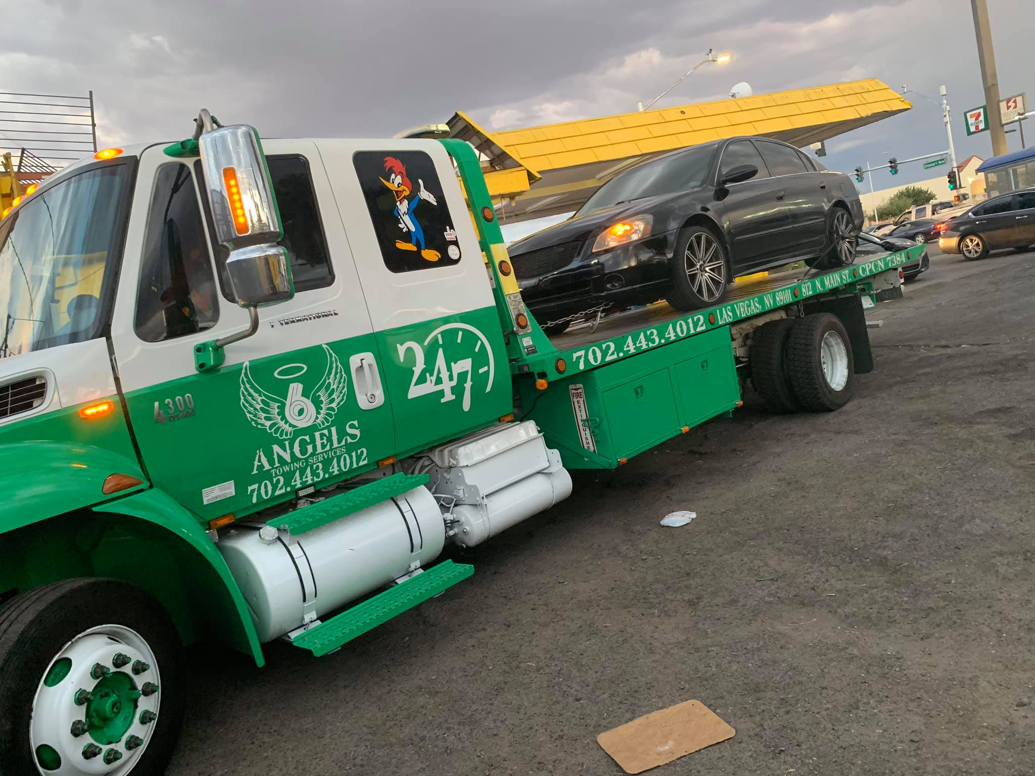 6 Angels tow truck hauling a vehicle at dusk in Las Vegas